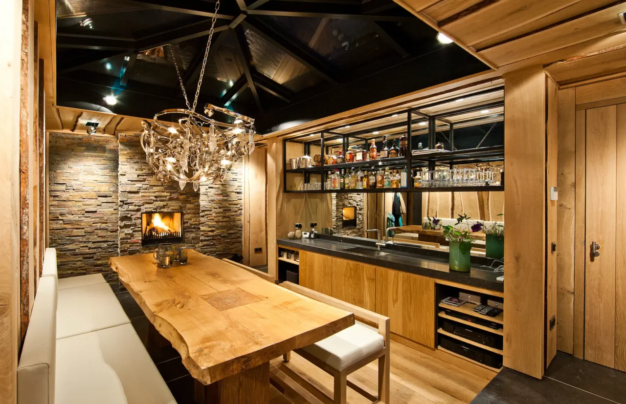 High-end woonkeuken in project City Garden met robuuste boomstamtafel, natuurstenen haardwand en moderne bar door ERIC KANT.
