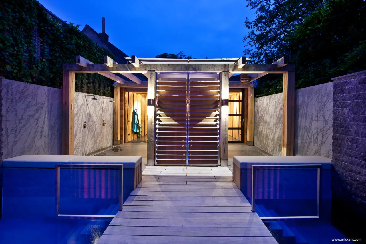 Verlicht zwembad en luxe wellnessruimte in project City Garden met eikenhouten pergola, buitendouches en lamellenscherm door ERIC KANT.