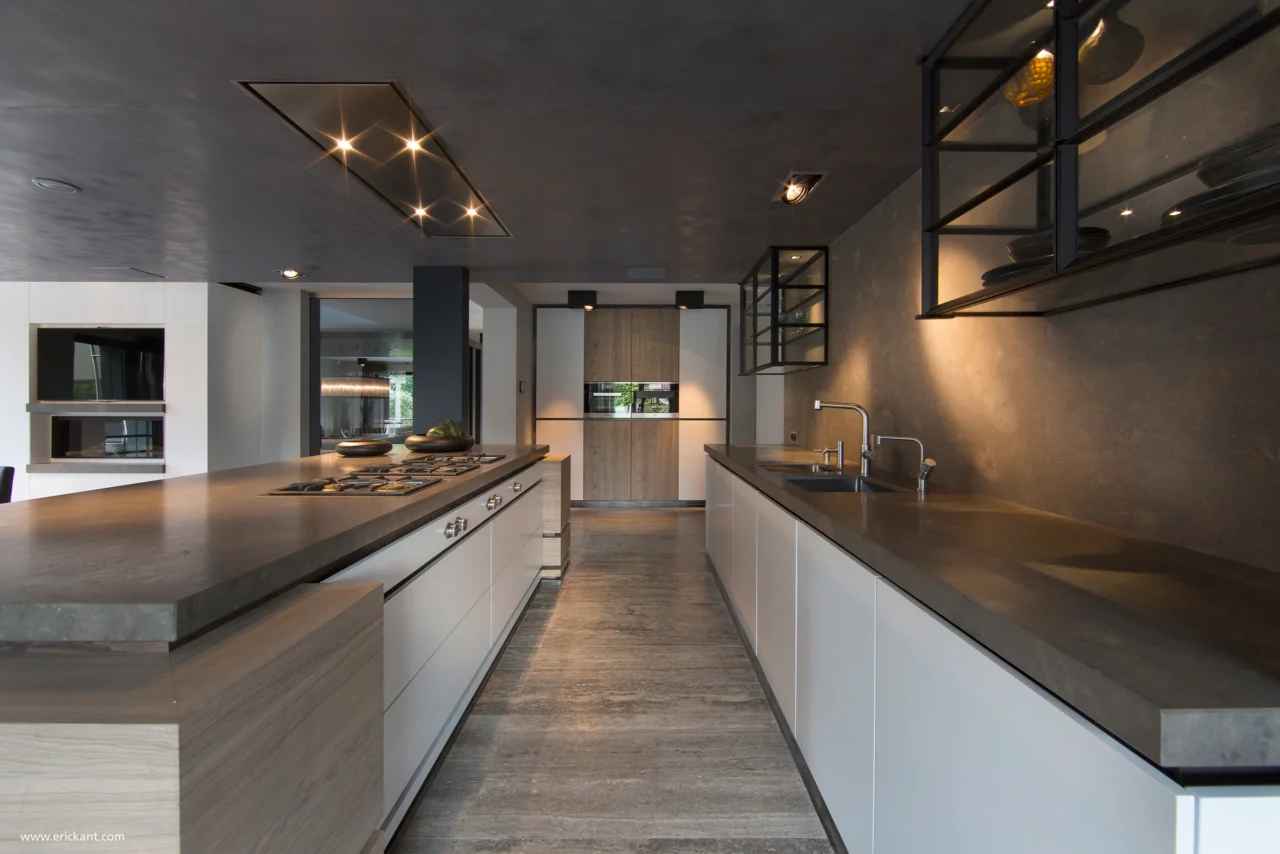 Luxe keuken in project Family Country House met wit kookeiland, natuurstenen werkbladen, zwarte vitrinekasten en geïntegreerde plafondverlichting door ERIC KANT.