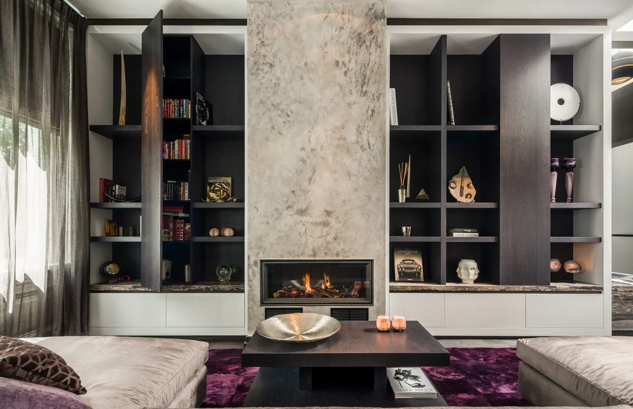 Exclusief maatwerk wandmeubel in Riga met geïntegreerde gashaard, open vakkenkast en betonstuc afwerking door ERIC KANT.