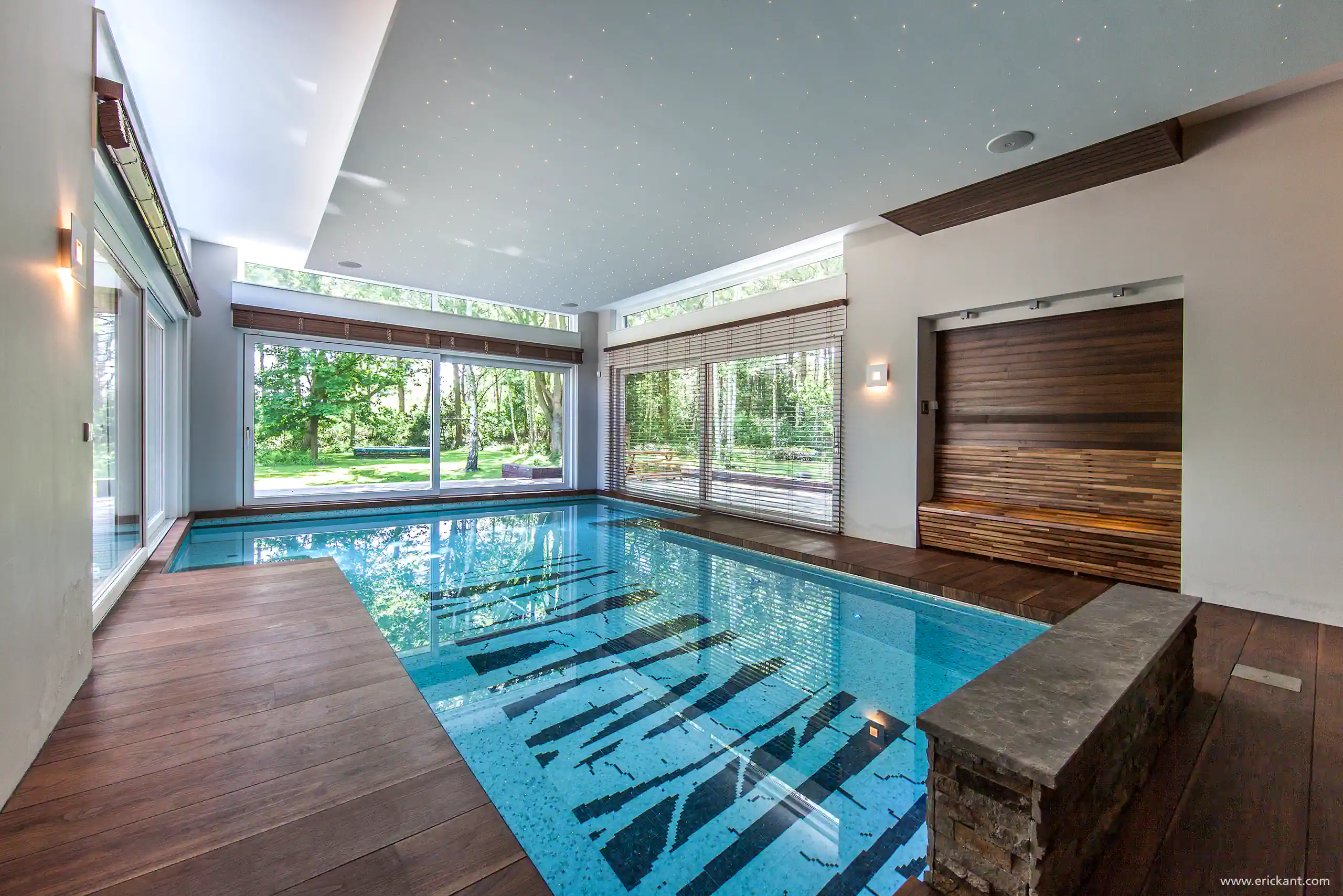 High-end binnenzwembad in het Luxury Bungalow project door ERIC KANT met een houten deck, een sterrenhemel plafond, grote schuifpuien naar de tuin en een sfeervolle rustruimte in hout.