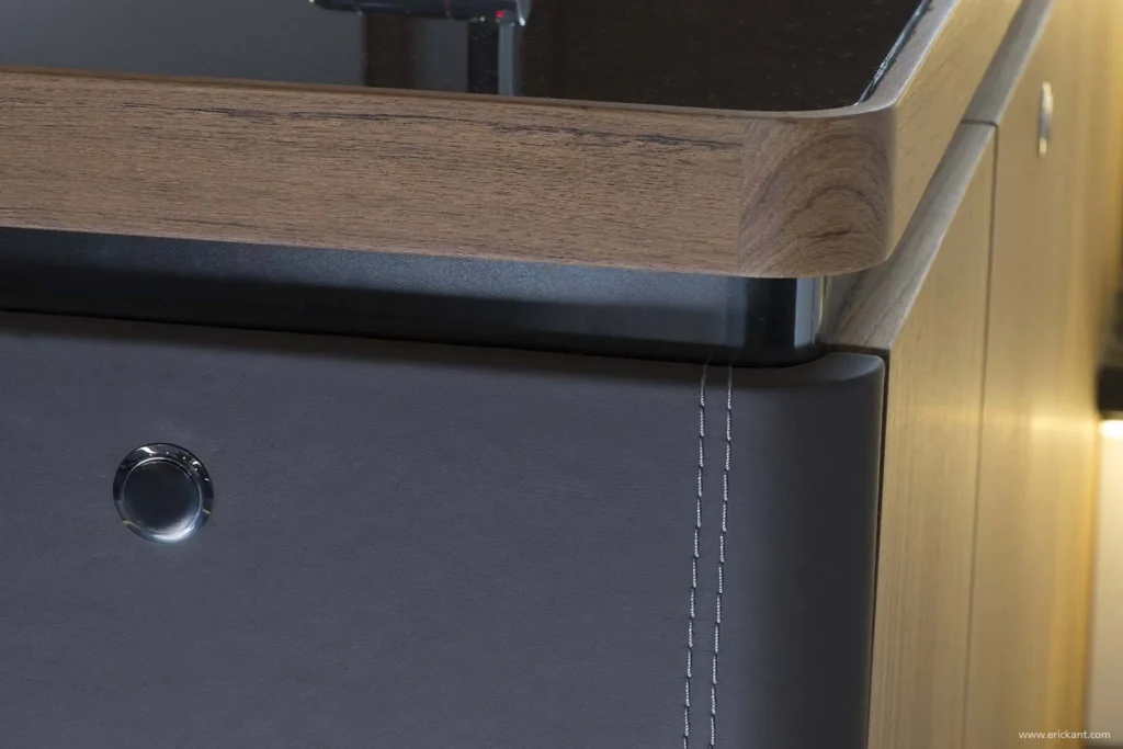 Hoogwaardig detail van een jachtinterieur ontworpen door Eric Kant, met met de hand gestikt leer, rond afgewerkte houten details en een moderne drukknopsluiting.