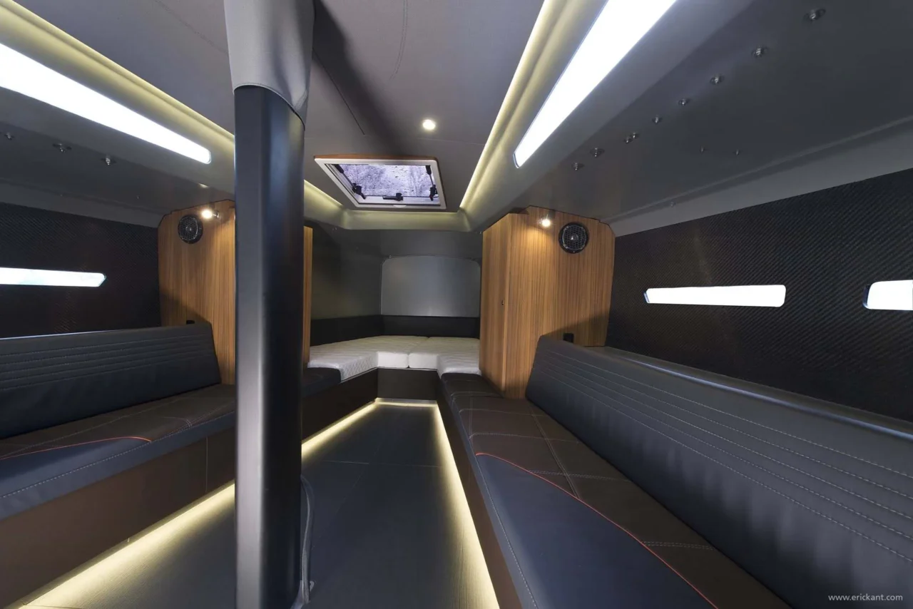 Modern interieur van de Agile Yacht cabine ontworpen door Eric Kant, met donkerleren loungebanken, wanden van carbonfiber, eikenhouten accenten en sfeervolle indirecte led-verlichting.