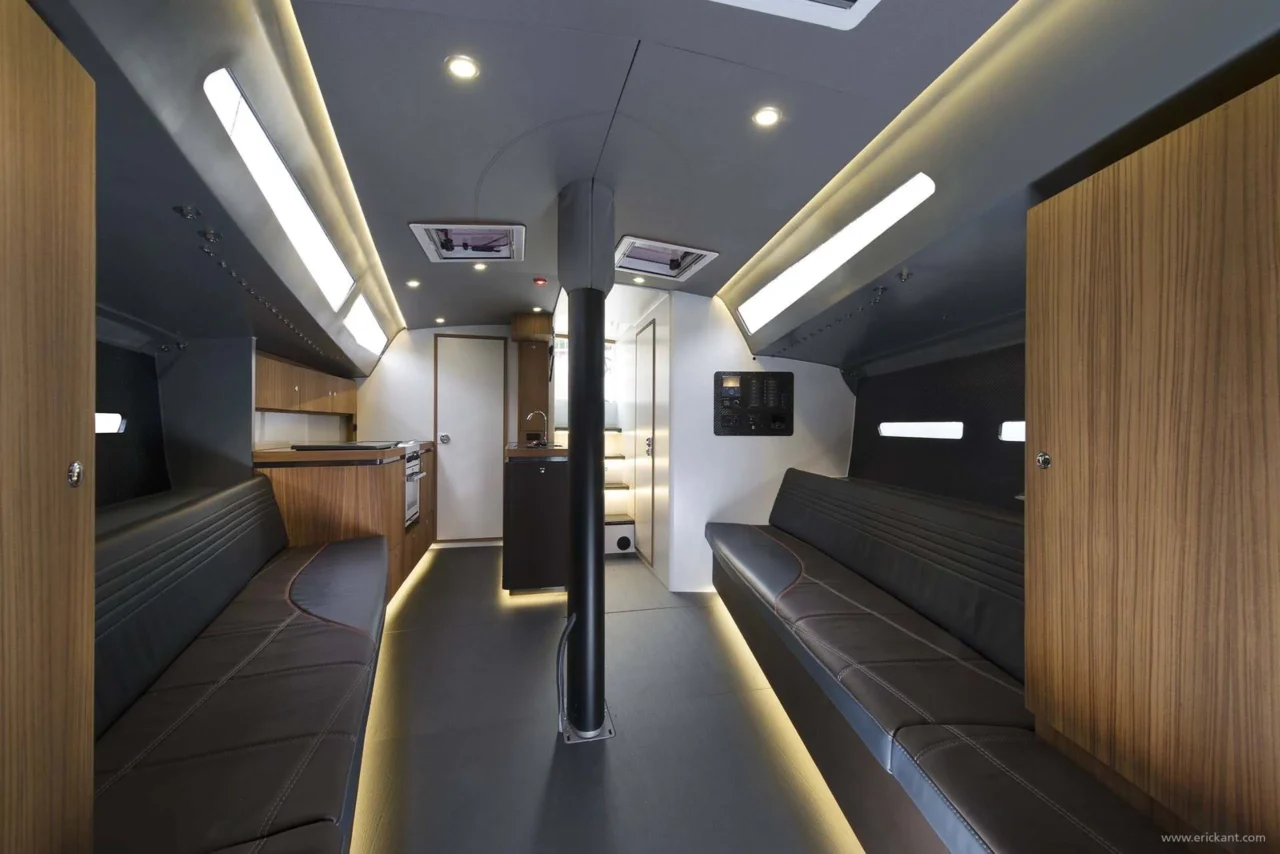 Volledig interieuroverzicht van de Agile Yacht cabine door Eric Kant, met een houten keuken, luxe leren loungebanken, carbonfiber details en een doordacht lichtplan met led-verlichting.