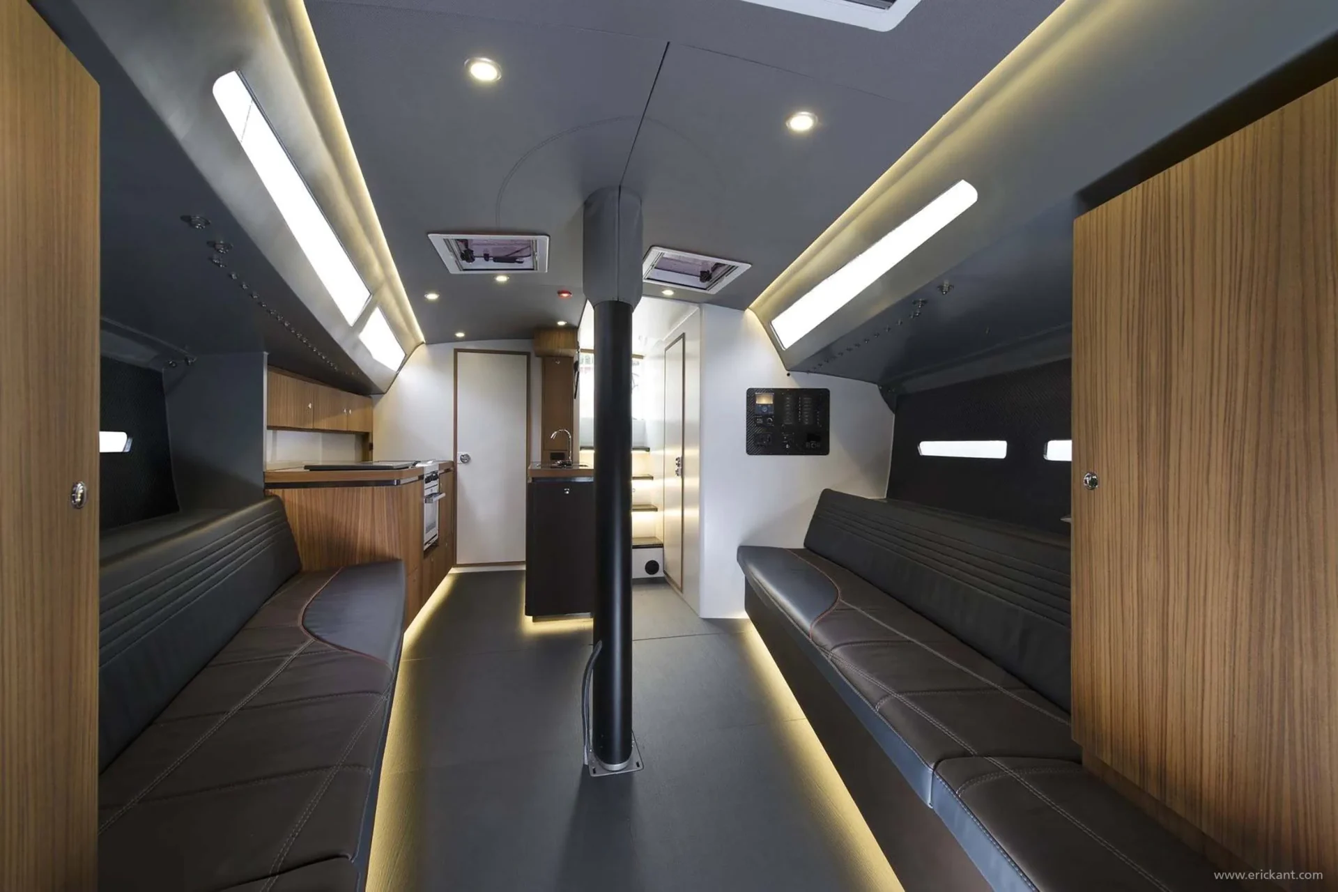 Volledig interieuroverzicht van de Agile Yacht cabine door Eric Kant, met een houten keuken, luxe leren loungebanken, carbonfiber details en een doordacht lichtplan met led-verlichting.