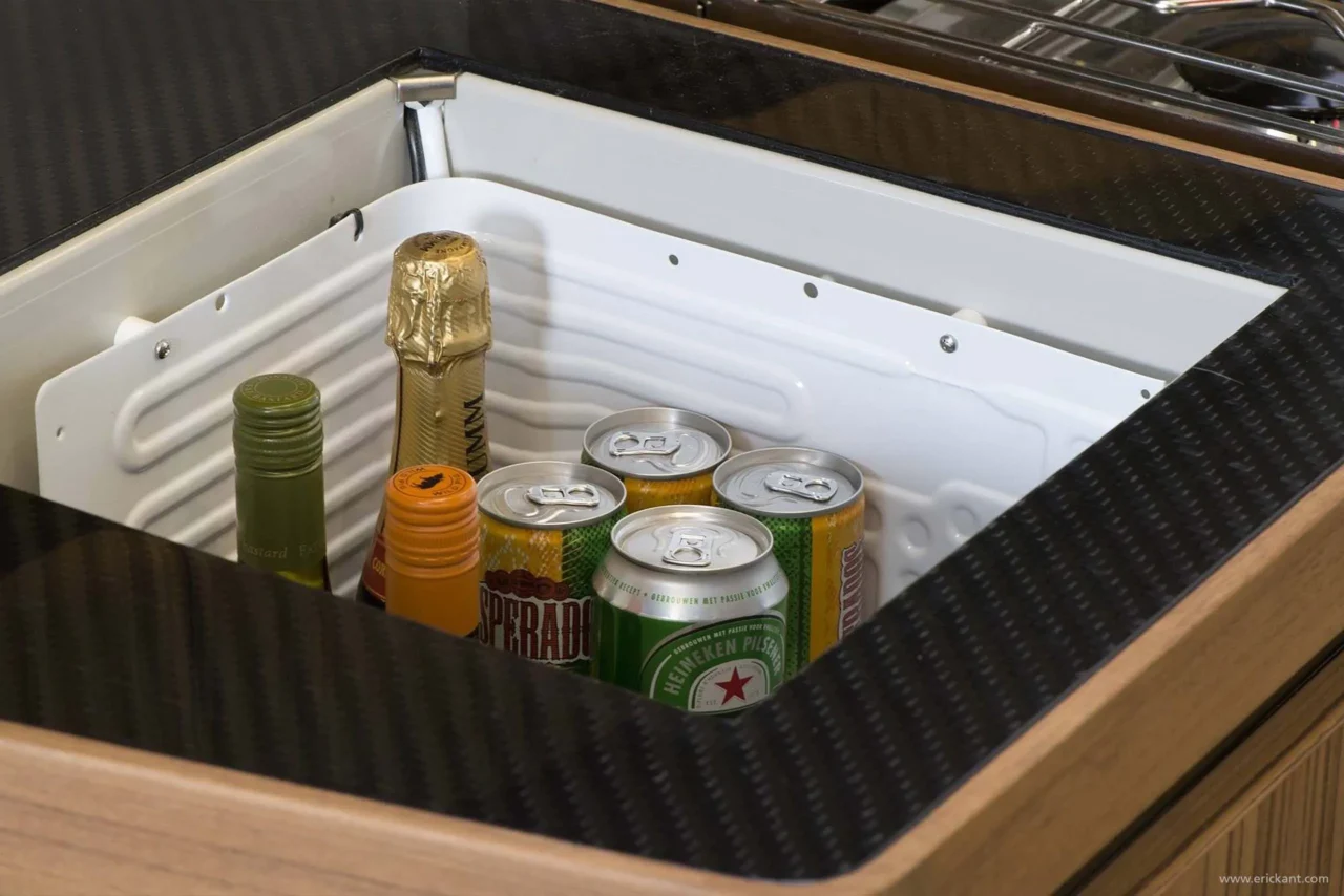 Detail van een luxe koellade aan boord van een jacht ontworpen door Eric Kant, met een ombouwing van carbonfiber en eikenhouten accenten.