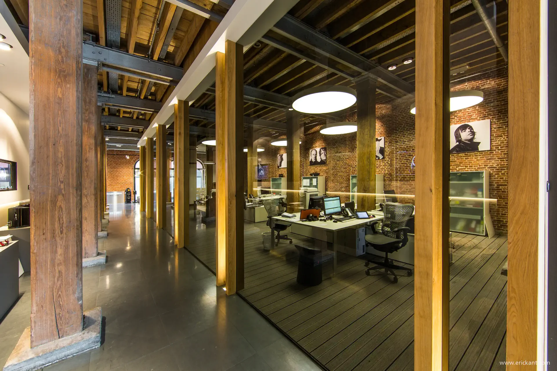 Interieur van het Bowers & Wilkins kantoor in Antwerpen door ERIC KANT, met een combinatie van authentieke bakstenen muren, houten steunbalken, glazen scheidingswanden en moderne werkplekken.