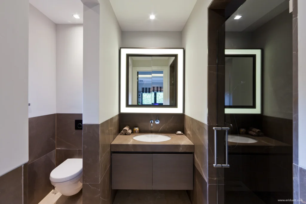 High-end badkamerinterieur van project New Classic Villa met een marmeren wastafelmeubel, een vierkante verlichte spiegel en een glazen douchewand door ERIC KANT.