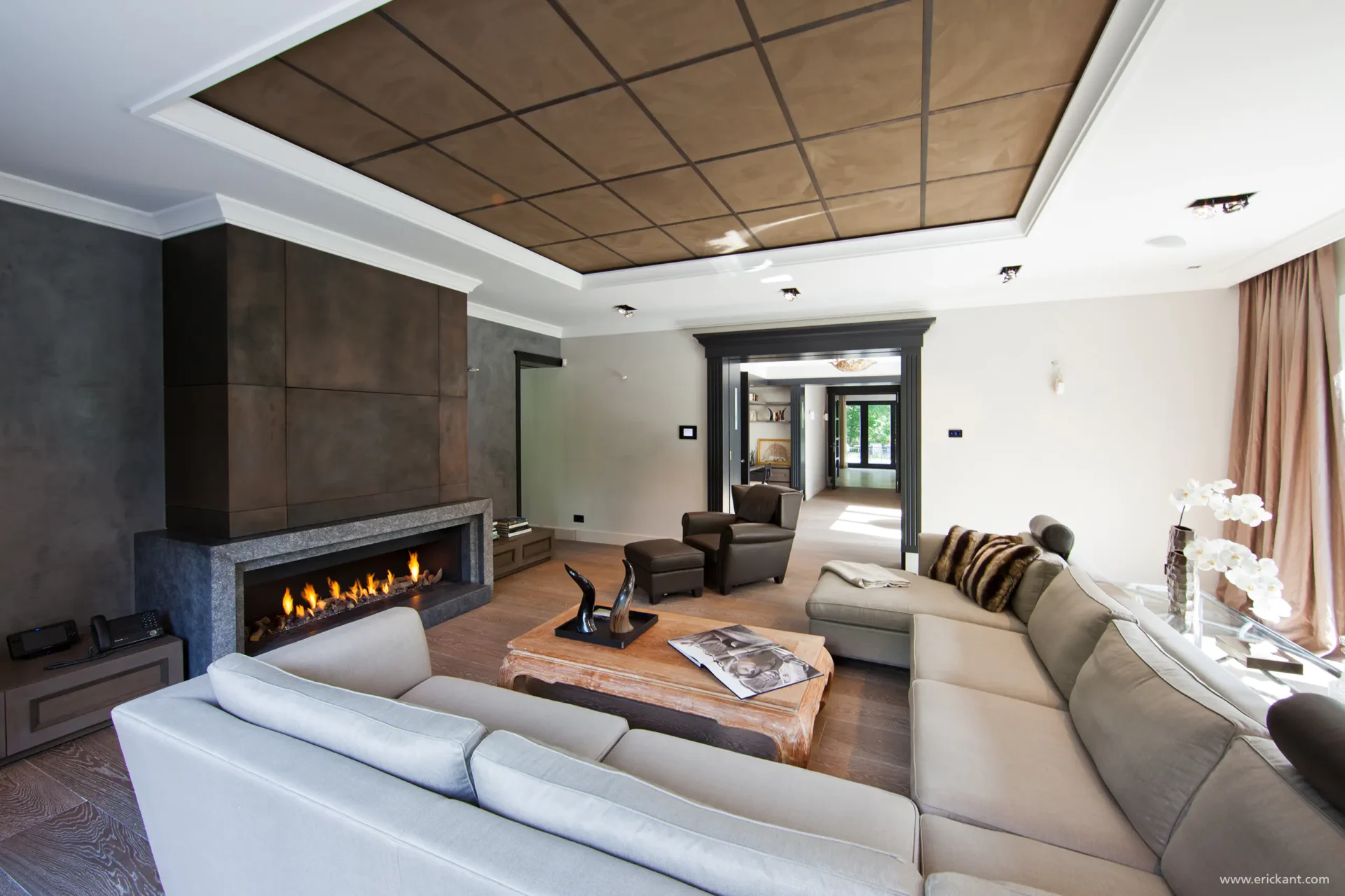 High-end woonkamerinterieur van project New Classic Villa met een grote gashaard, lederen plafondpanelen, modulaire bank en doorkijk naar de hal door ERIC KANT.