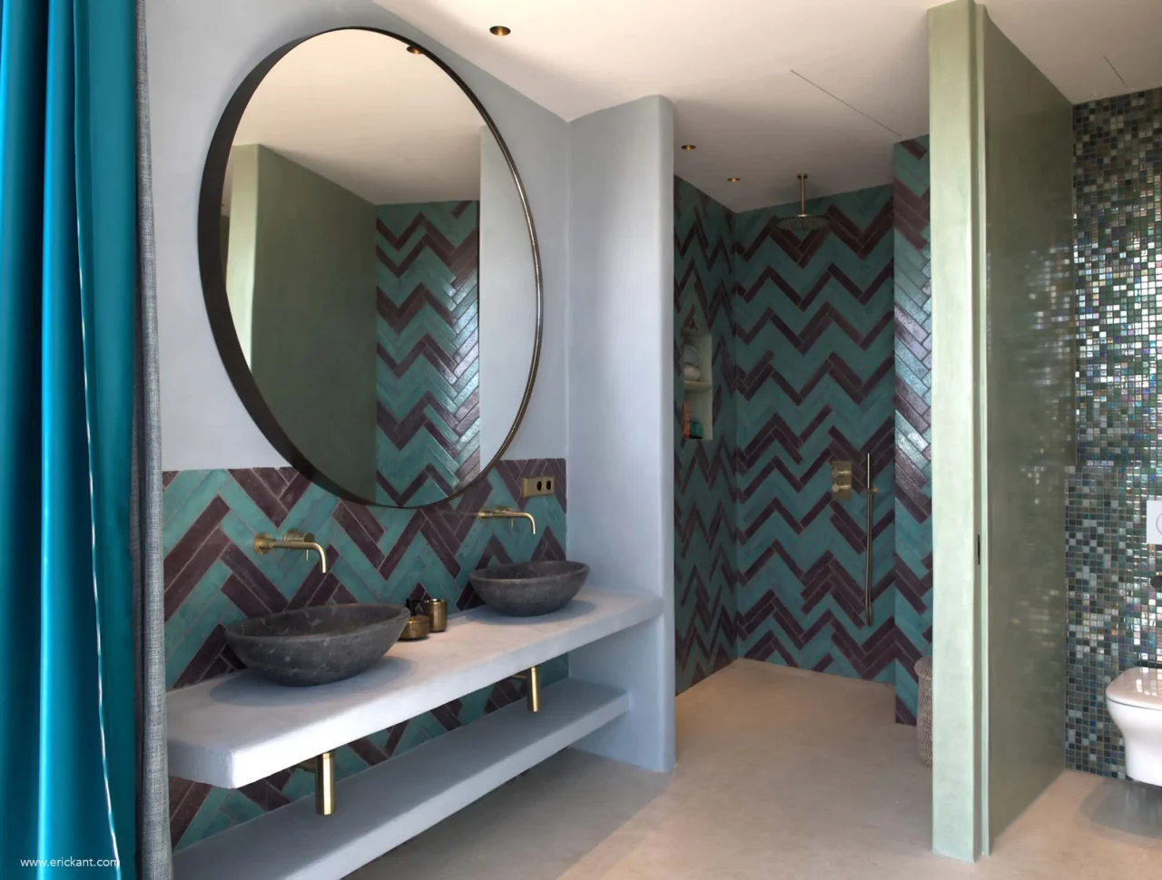 High-end badkamer met kleurrijke visgraat tegels, dubbele natuurstenen waskommen en gouden kranen in project Cali Moli Ibiza.