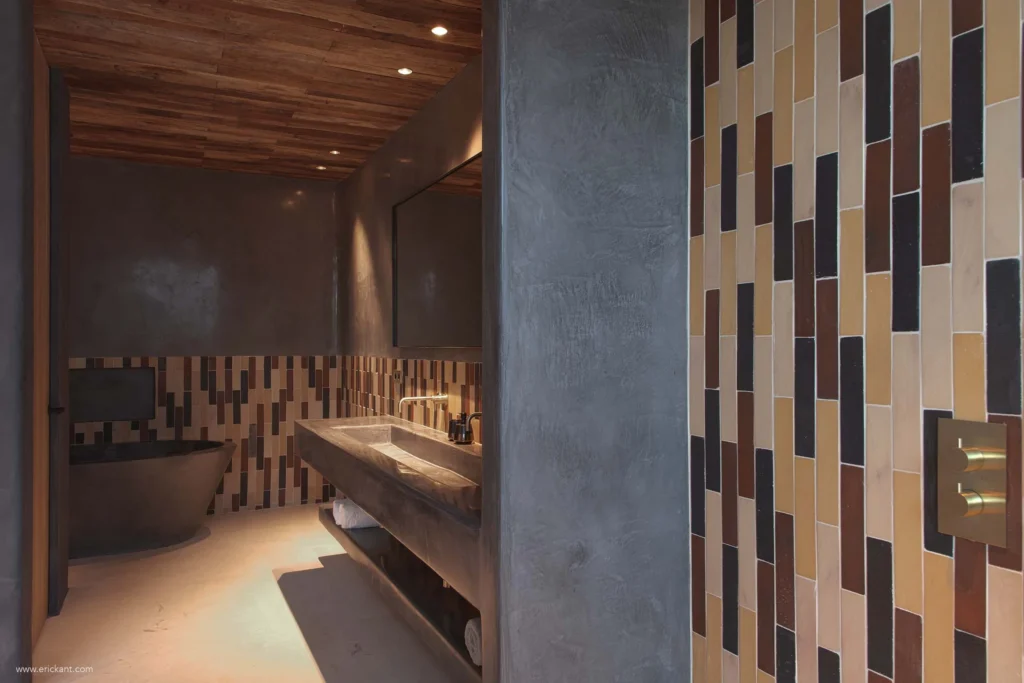 High-end badkamer met betonnen wastafelmeubel, vrijstaand bad en verticaal tegelpatroon in project Cali Moli Ibiza door ERIC KANT.