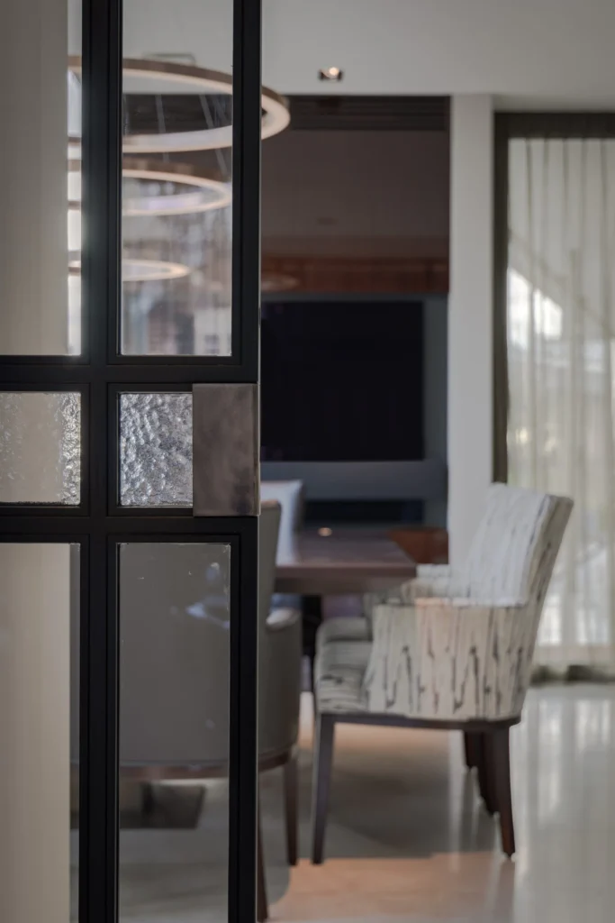 Detail van een zwarte stalen deur in de Modern Classic Villa met verschillende soorten glas, waaronder monumentenglas, en een robuuste bronzen handgreep door ERIC KANT.