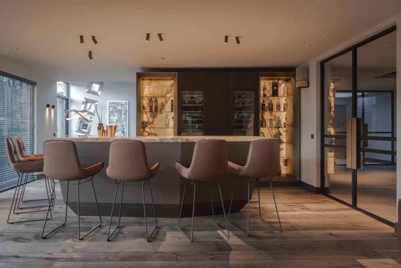 High-end maatwerk inloopkast in de Metropolitan Luxury villa met kamerhoge donkere eikenhouten kasten, LED-verlichting onder de planken en een spiegel achterwand door ERIC KANT.