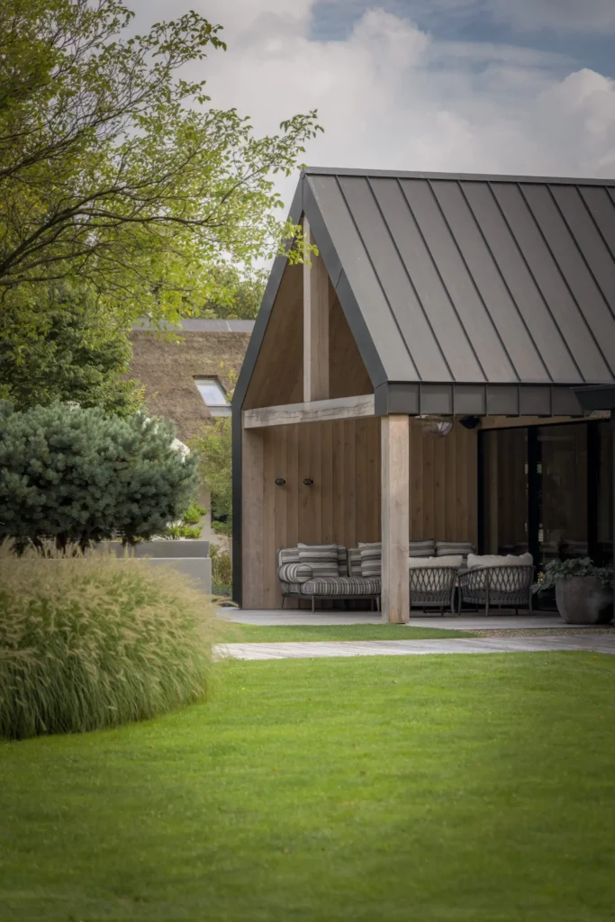 Exclusief interieurontwerp door Eric Kant, met een moderne zwarte trap, een glazen balustrade en een imposant hoog houten plafond in een vide, uitkijkend op de eethoek.