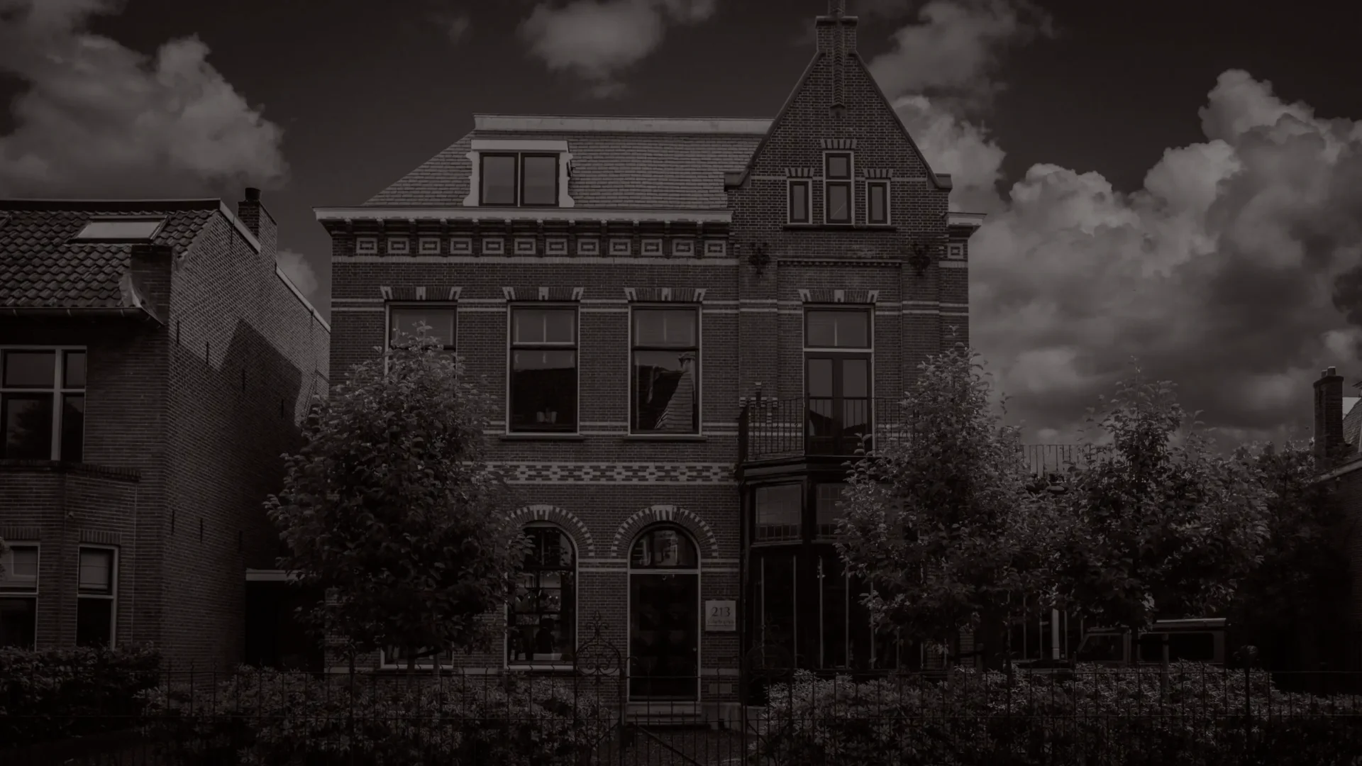 Een sfeervolle zwart-wit foto van het karakteristieke herenhuis in Breda waarin het kantoor van interieurarchitect ERIC KANT is gevestigd, met een indrukwekkende gevel en klassieke architectonische details.